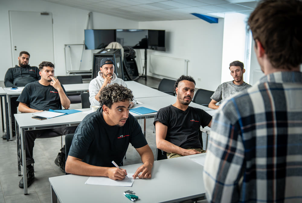 Unterricht im DIALOG-Klassenraum in Nottuln: internationale Fahrschüler folgen dem Kurs